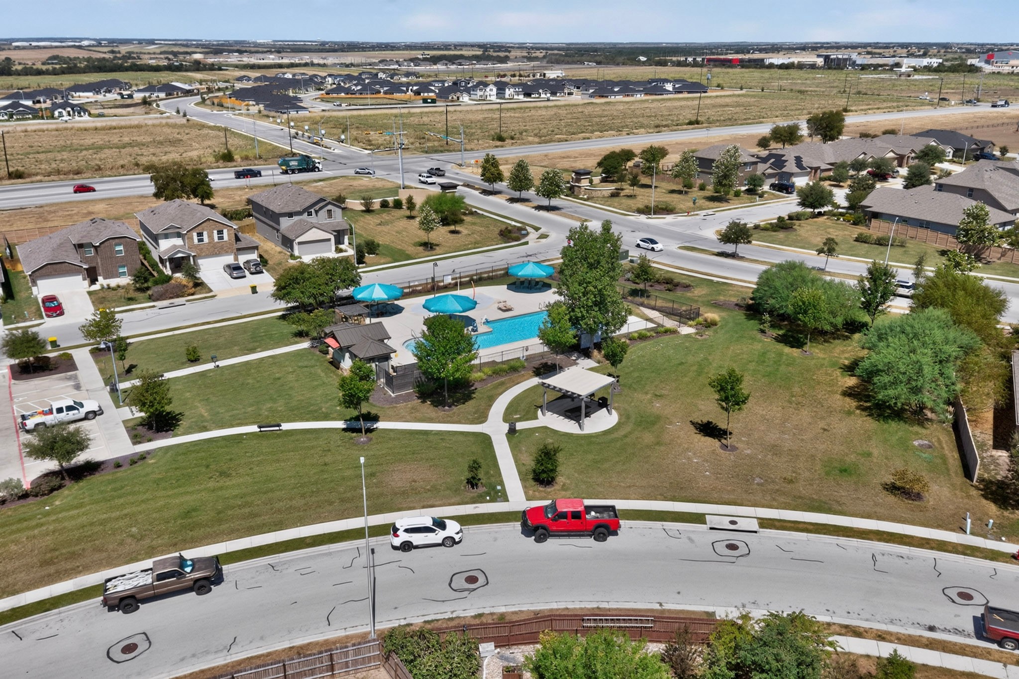 11612 Andesite Road Manor, TX 78653 - Photo 31 of 40 An inviting community pool and green space anchor this suburban neighborhood setting.