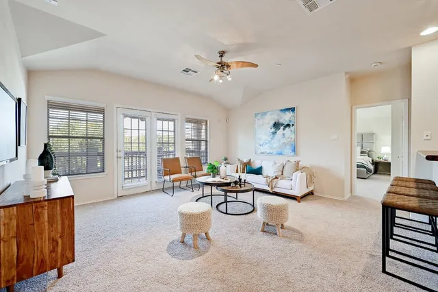 a living room with furniture a flat screen tv and a large window