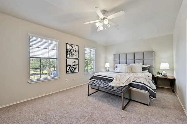 a spacious bedroom with a bed couch and window