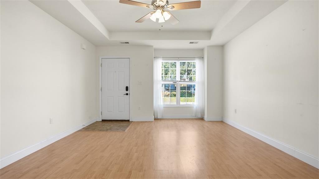 607 Locust Street Coraopolis, PA 15108 - Photo 6 of 18 an empty room with wooden floor chandelier fan and windows