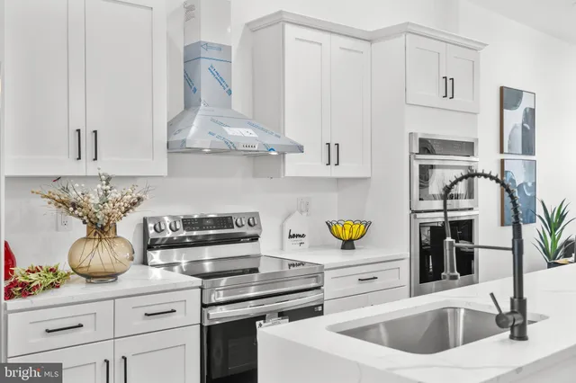a kitchen with stainless steel appliances a sink a stove and cabinets