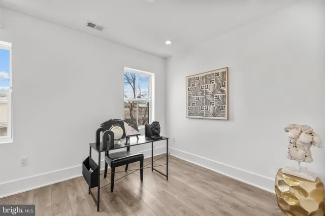 a view of a workspace with furniture and wooden floor