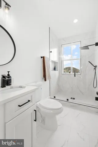 a bathroom with a sink a toilet and a mirror