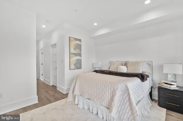 a spacious bedroom with a bed and a lamp