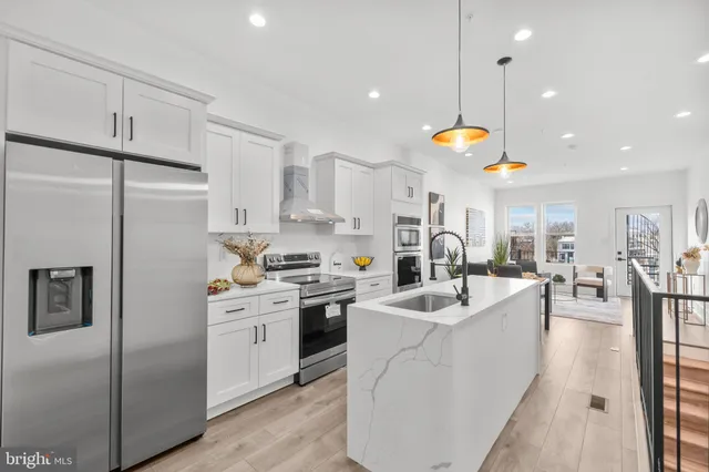 a kitchen with stainless steel appliances granite countertop a sink a stove and a refrigerator