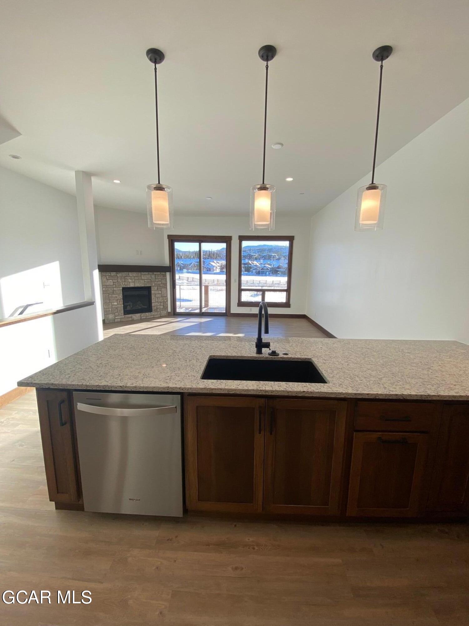 168 Hay Meadow Drive Fraser, CO 80442 - Photo 28 of 35 a kitchen with kitchen island a sink and a wooden floor