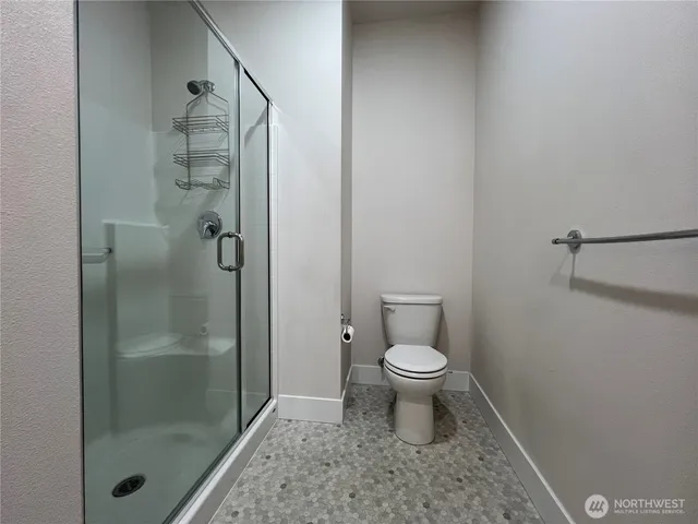 a bathroom with a toilet and a shower