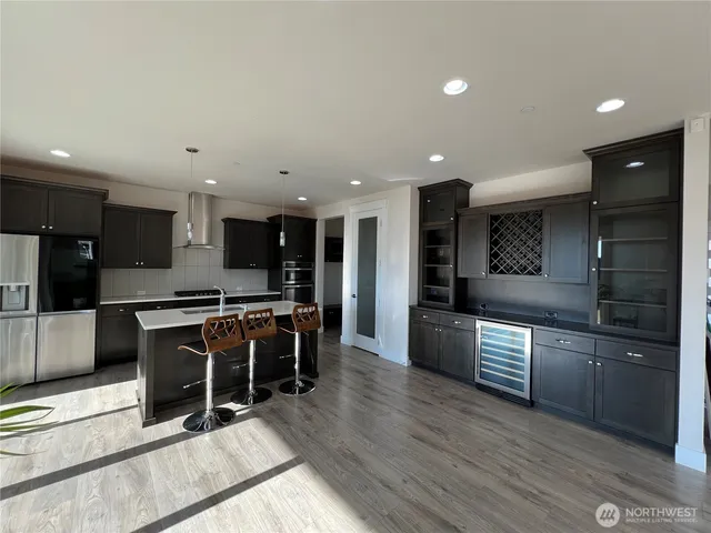 a kitchen with stainless steel appliances kitchen island granite countertop a stove and a refrigerator