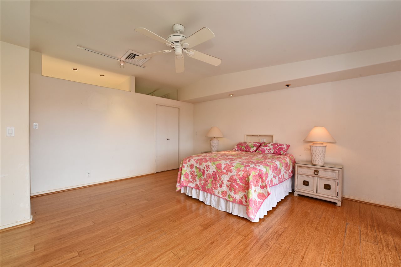 166 Halelo Street Lahaina, HI 96761 - Photo 14 of 27 a bedroom with a bed and a chandelier