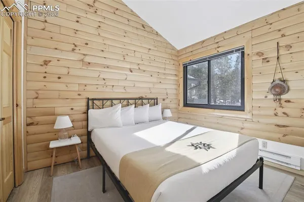 a bedroom with a bed and a lamp next to a window