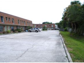 1300 Northeast Arlington, Unit 124 Palm Bay, FL 32905 - Photo 2 of 6 a view of a street with a building and trees in the background