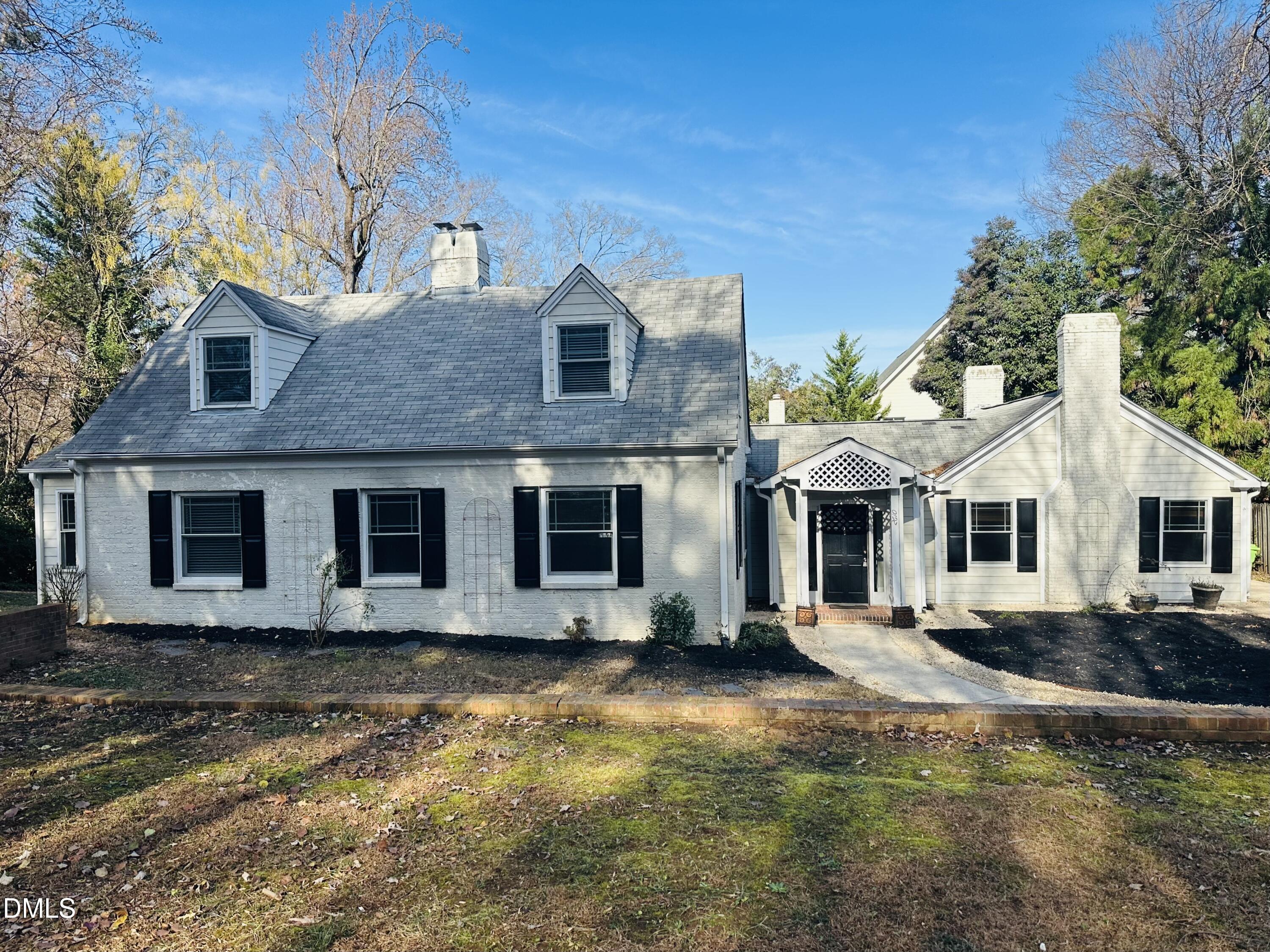 a front view of a house with yard and trees around