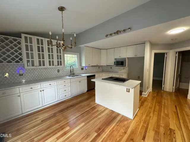 a kitchen with granite countertop a sink cabinets and wooden floor