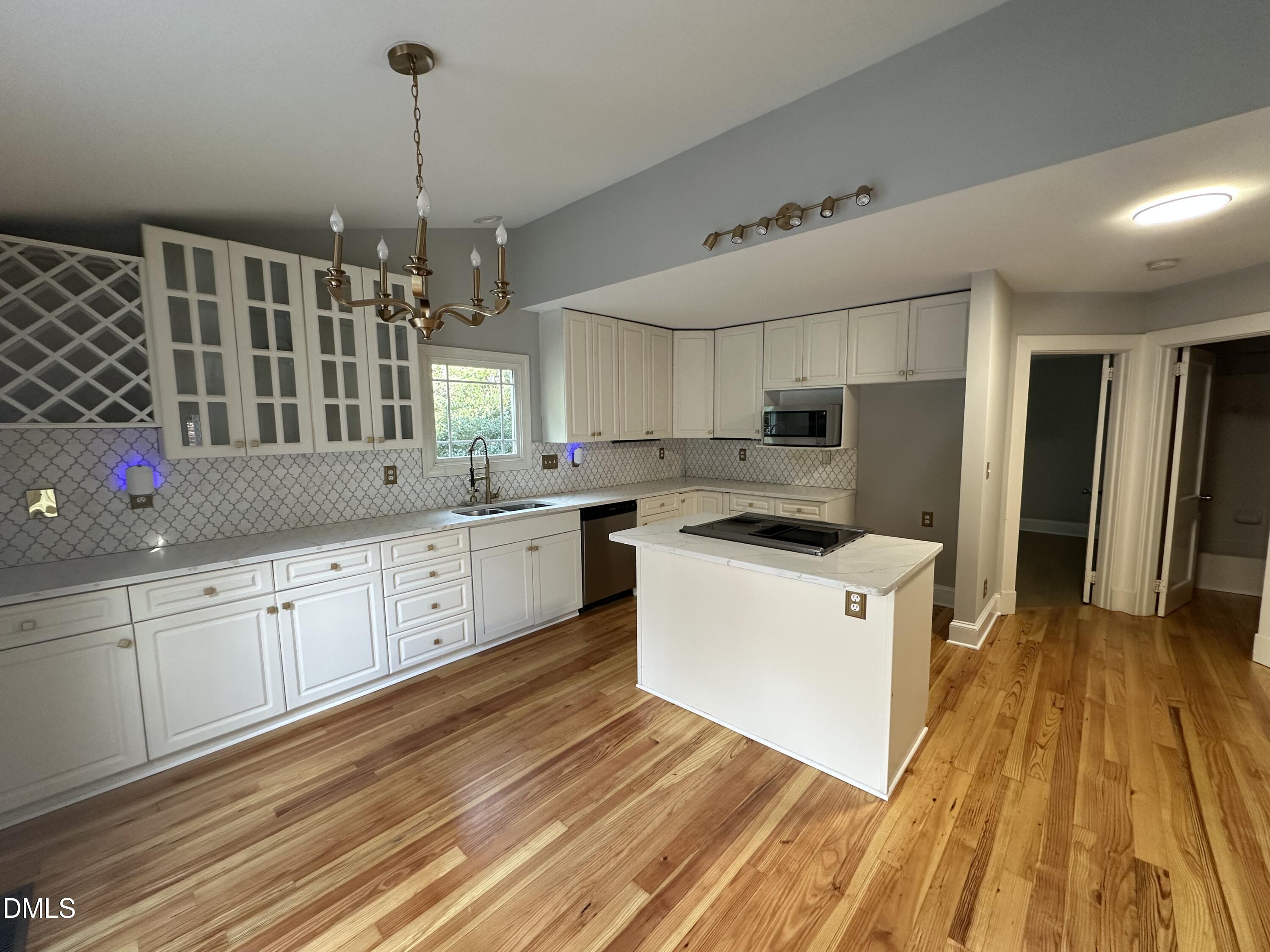2610 Dover Road Raleigh, NC 27608 - Photo 15 of 53 a kitchen with cabinets wooden floor and stainless steel appliances