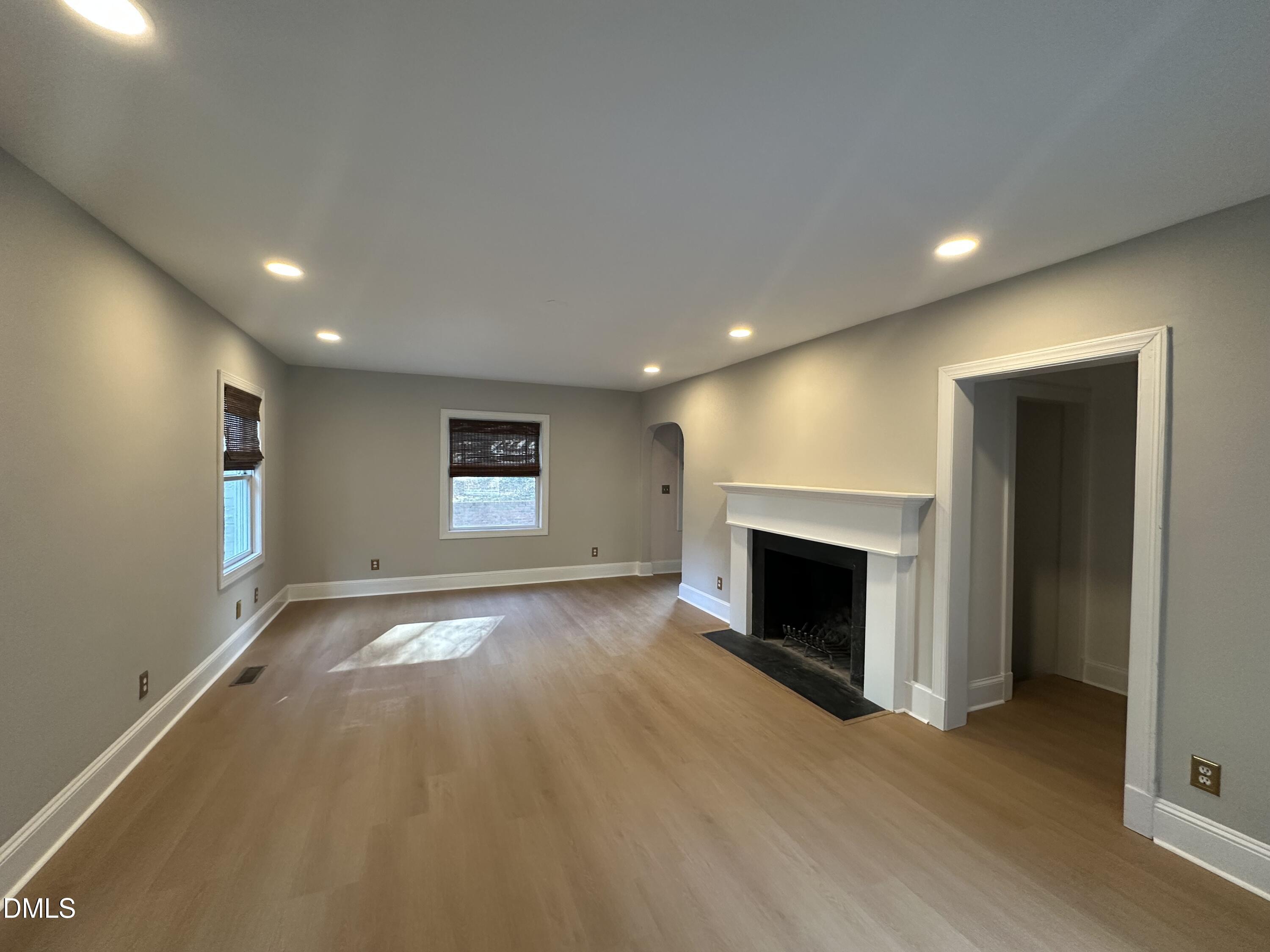 2610 Dover Road Raleigh, NC 27608 - Photo 23 of 53 an empty room with wooden floor fireplace and windows