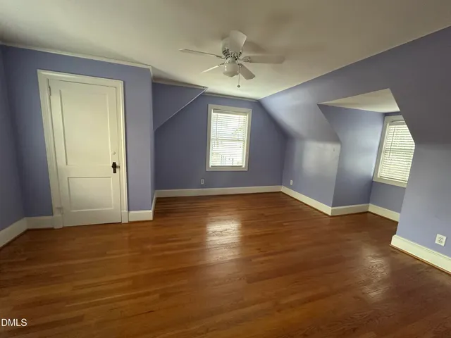 a view of empty room with window ceiling fan and hardwood floor
