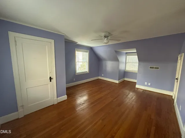 a view of empty room with wooden floor
