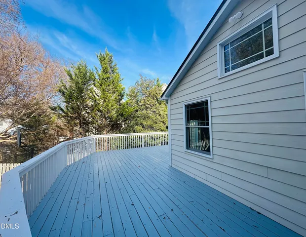 a view of a house with wooden deck and a yard