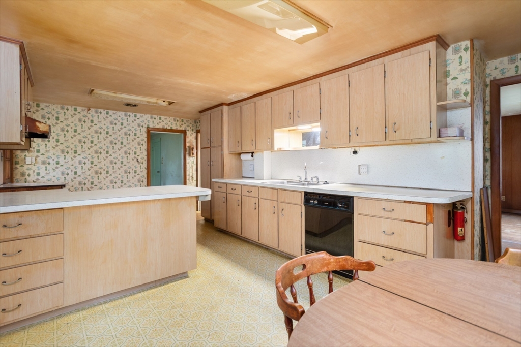 35 Summer Street Saugus, MA 01906 - Photo 13 of 31 a large kitchen with stainless steel appliances granite countertop a stove a sink dishwasher and white cabinets with wooden floor