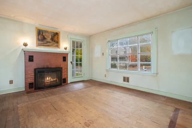 a view of an empty room with window and fire place
