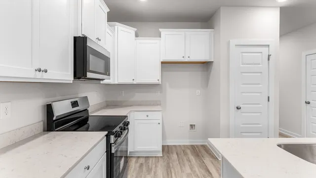 a kitchen with a sink a stove and cabinets