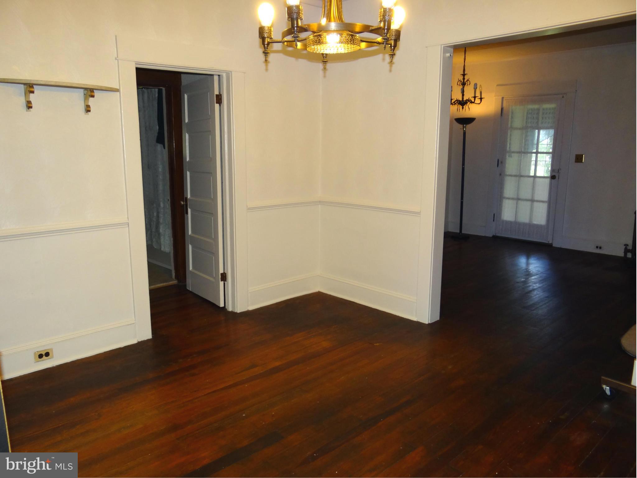 2902 Ridge Road Baltimore, MD 21244 - Photo 3 of 23 an empty room with wooden floor chandelier and windows