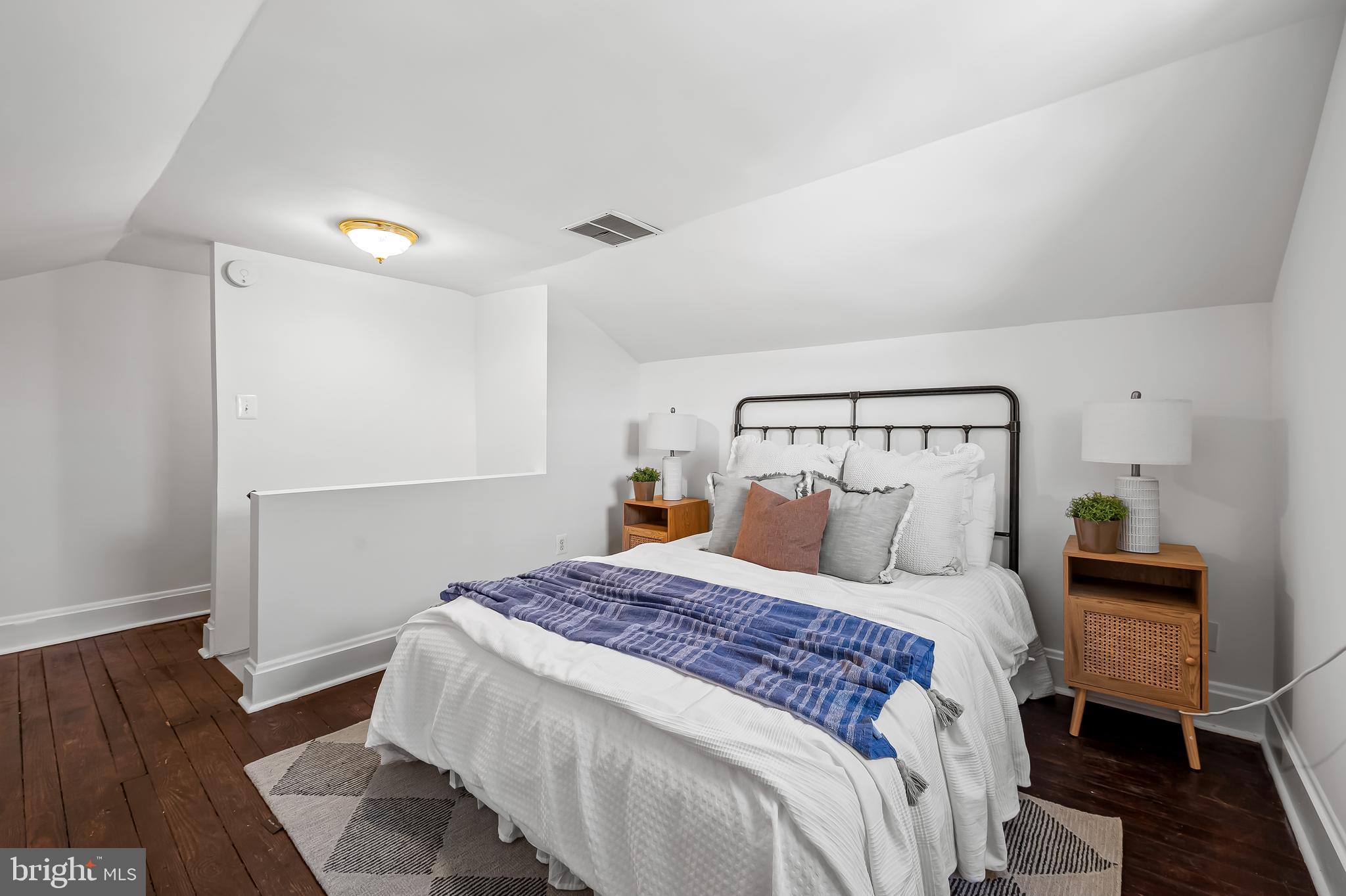 1015 Rectory Lane Baltimore, MD 21211 - Photo 18 of 28 a bedroom with a bed and wooden floor