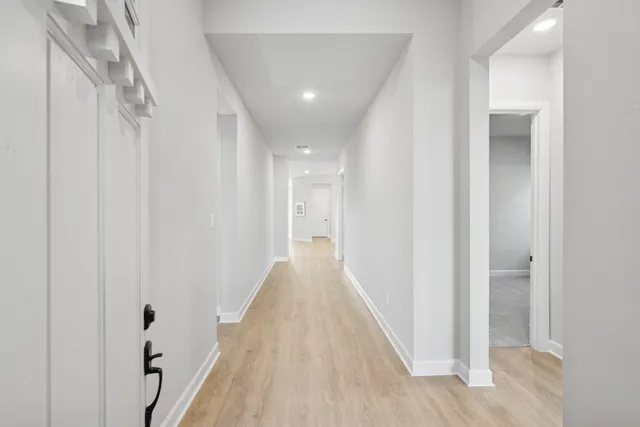 a view of a hallway with wooden floor and staircase