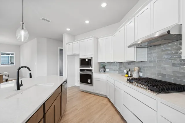 a kitchen with sink a stove and cabinets