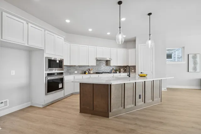 a kitchen with kitchen island a sink and a stove