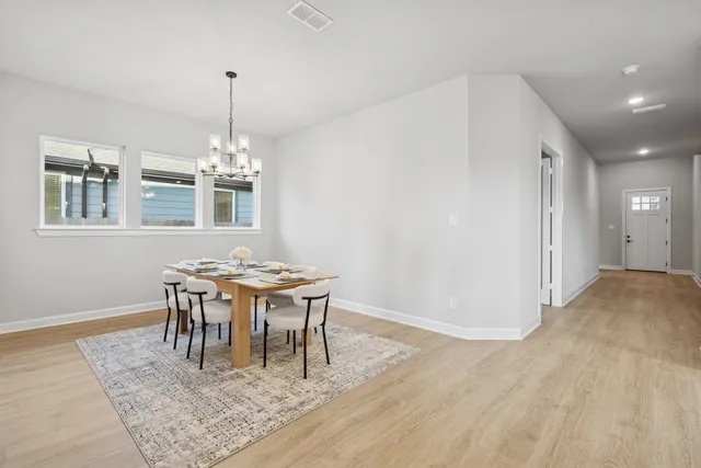 a view of a dining room with furniture wooden floor and chandelier
