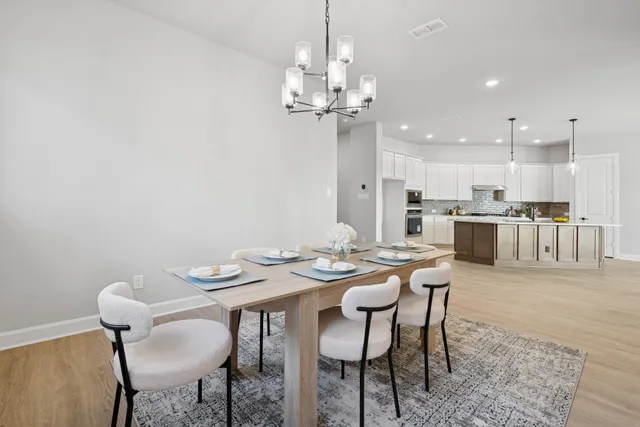 a view of a dining room with furniture and chandelier