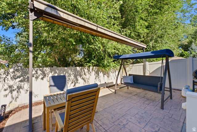7772 South Rustic Cove Midvale, UT 84047 - Photo 33 of 39 Outdoor entertaining space featuring dual shade structures with retractable canopies, permeable paver flooring, and mature tree coverage