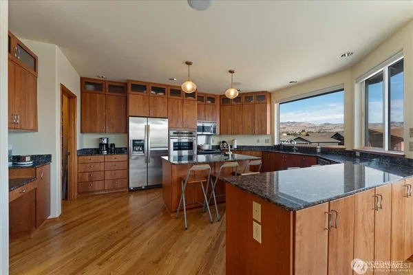 a kitchen with stainless steel appliances granite countertop a sink a stove and a refrigerator