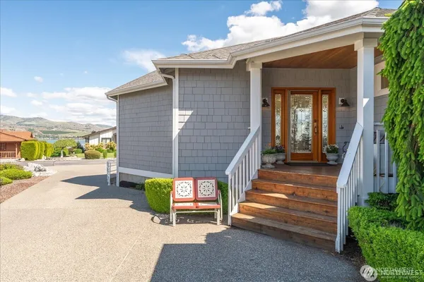 a kitchen with stainless steel appliances granite countertop a refrigerator a stove a sink and white cabinets with wooden floor