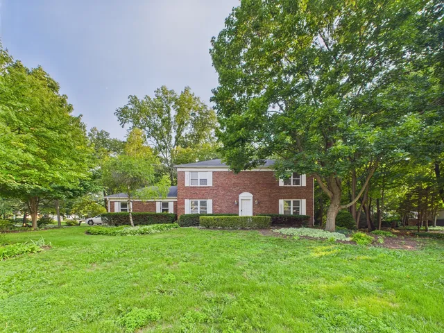 a view of a house with a yard and sitting area