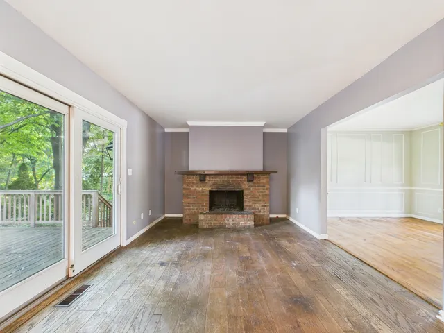 a view of a big room with wooden floor and a kitchen