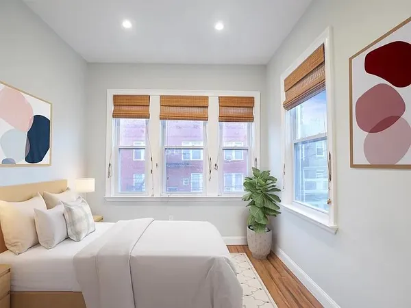 a bedroom with a bed and a potted plant