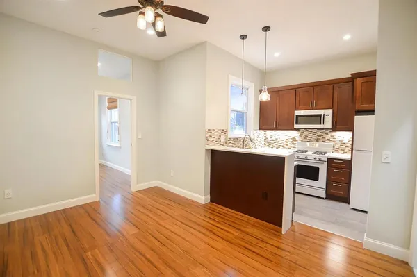 a kitchen with stainless steel appliances kitchen island granite countertop a refrigerator and a sink