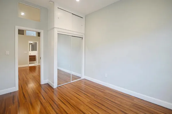 a view of empty room with wooden floor