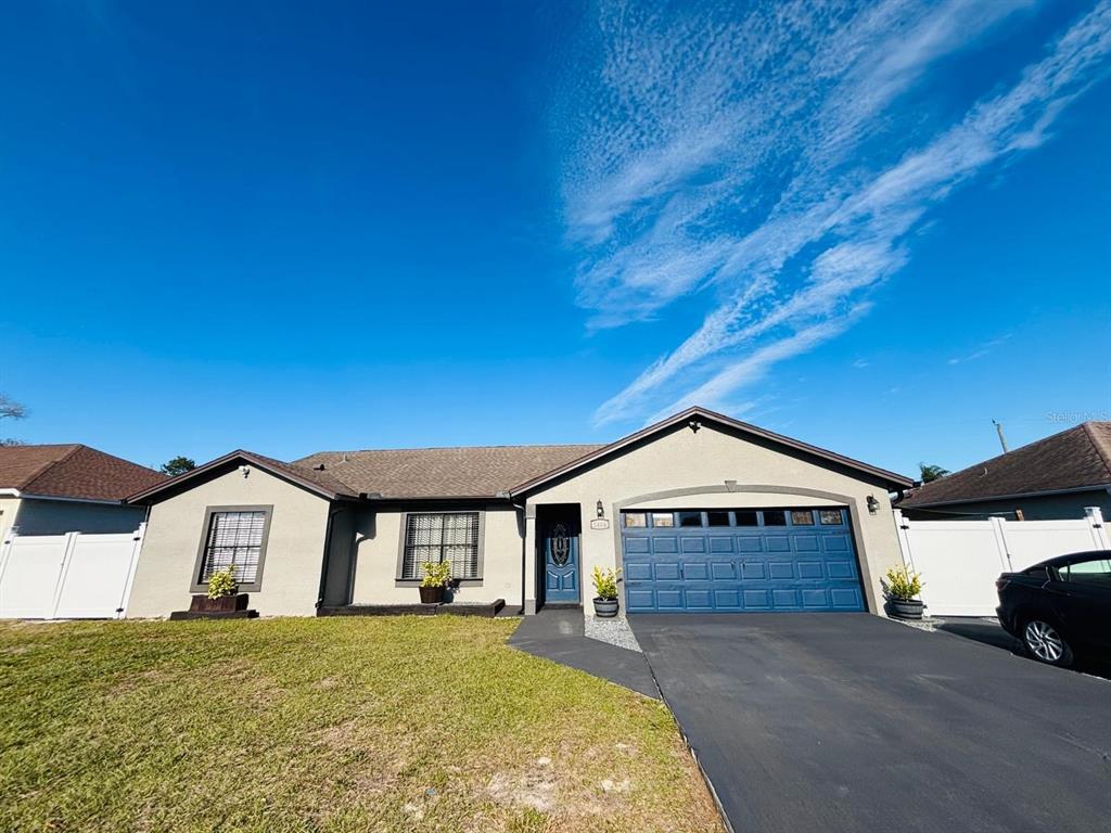 1464 Howland Boulevard Deltona, FL 32738 - Photo 1 of 55 a front view of a house with a yard and garage