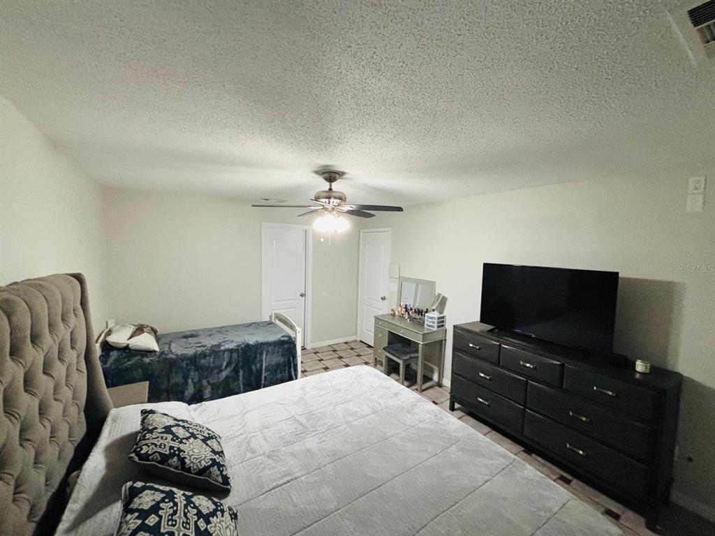 1464 Howland Boulevard Deltona, FL 32738 - Photo 15 of 55 a bedroom with a bed and a flat screen tv