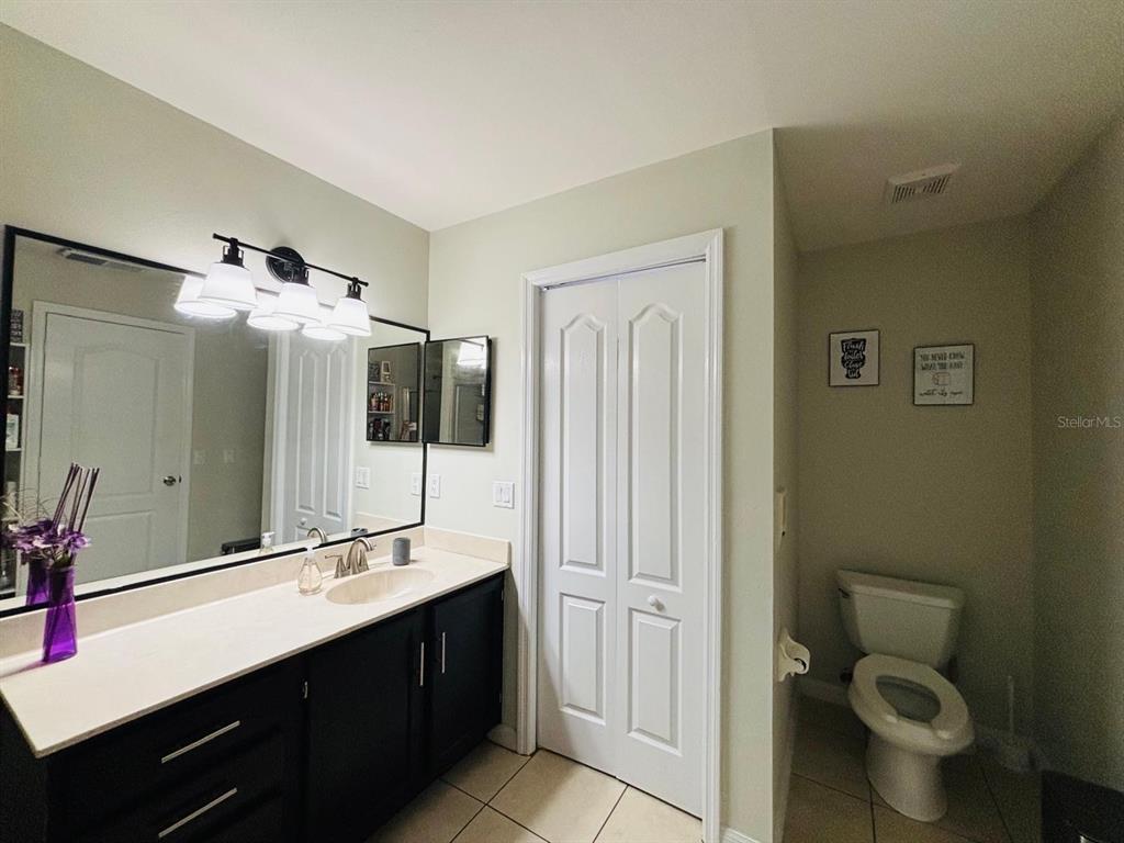 1464 Howland Boulevard Deltona, FL 32738 - Photo 17 of 55 a bathroom with a double vanity sink toilet and mirror