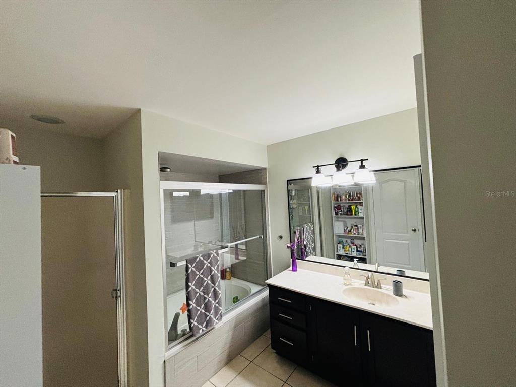 1464 Howland Boulevard Deltona, FL 32738 - Photo 18 of 55 a bathroom with a double vanity sink mirror and shower
