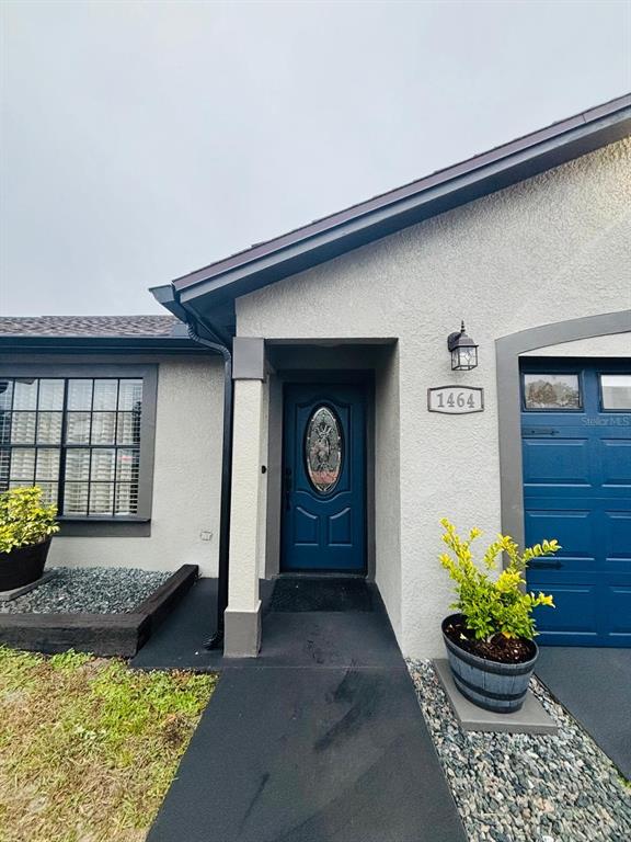 1464 Howland Boulevard Deltona, FL 32738 - Photo 2 of 55 a front view of a house with lots of potted plants