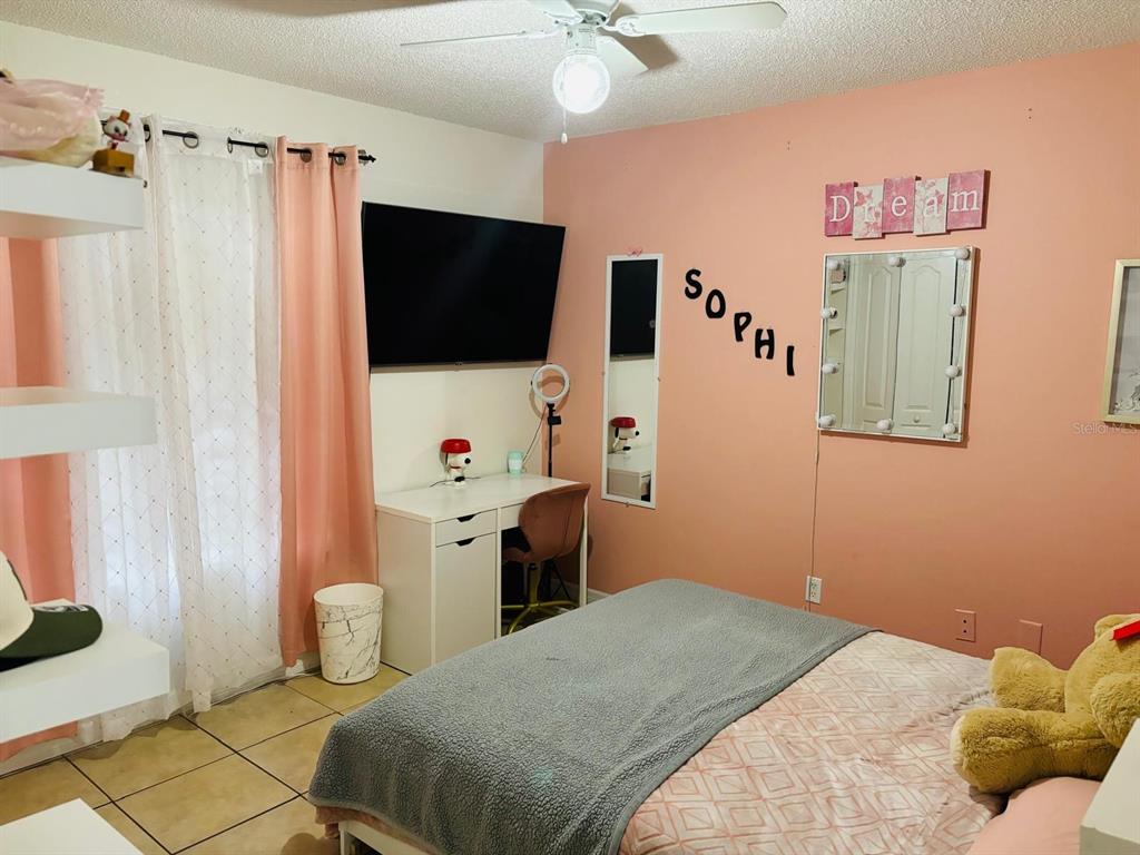 1464 Howland Boulevard Deltona, FL 32738 - Photo 23 of 55 a bedroom with a bed and a flat screen tv
