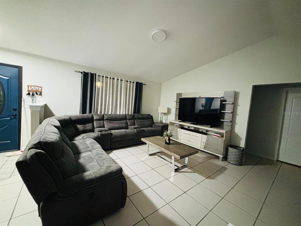 1464 Howland Boulevard Deltona, FL 32738 - Photo 6 of 55 a living room with furniture and a flat screen tv