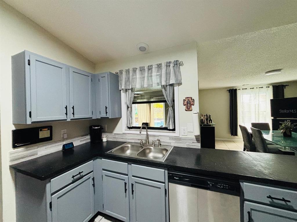 1464 Howland Boulevard Deltona, FL 32738 - Photo 10 of 55 a kitchen with granite countertop a sink a counter top space cabinets and stainless steel appliances