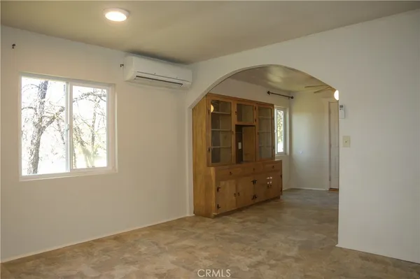 an empty room with windows and cabinet
