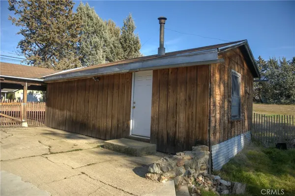 a view of barn house with a small yard and large tree
